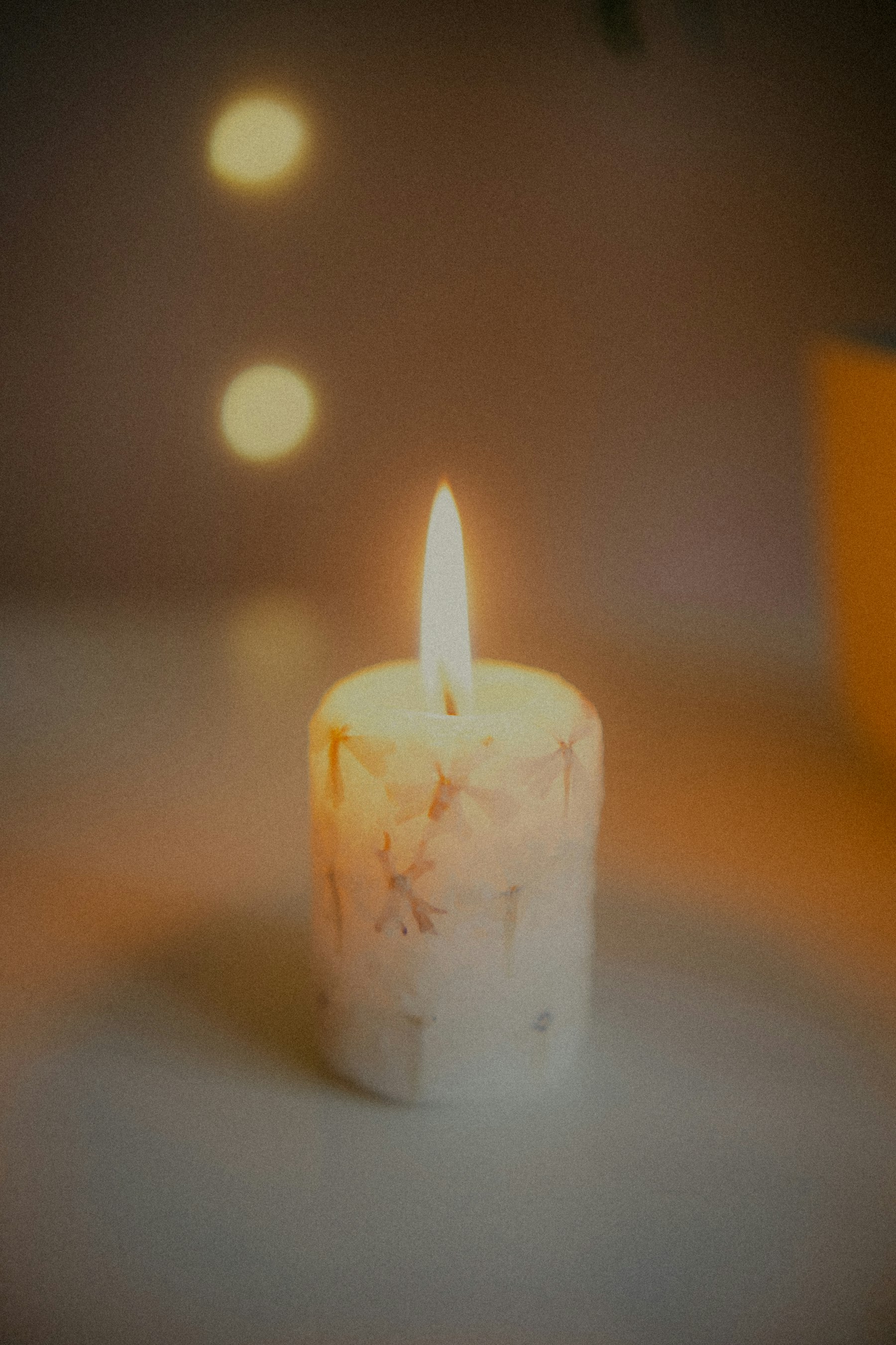 A lit candle in a softly blurred room