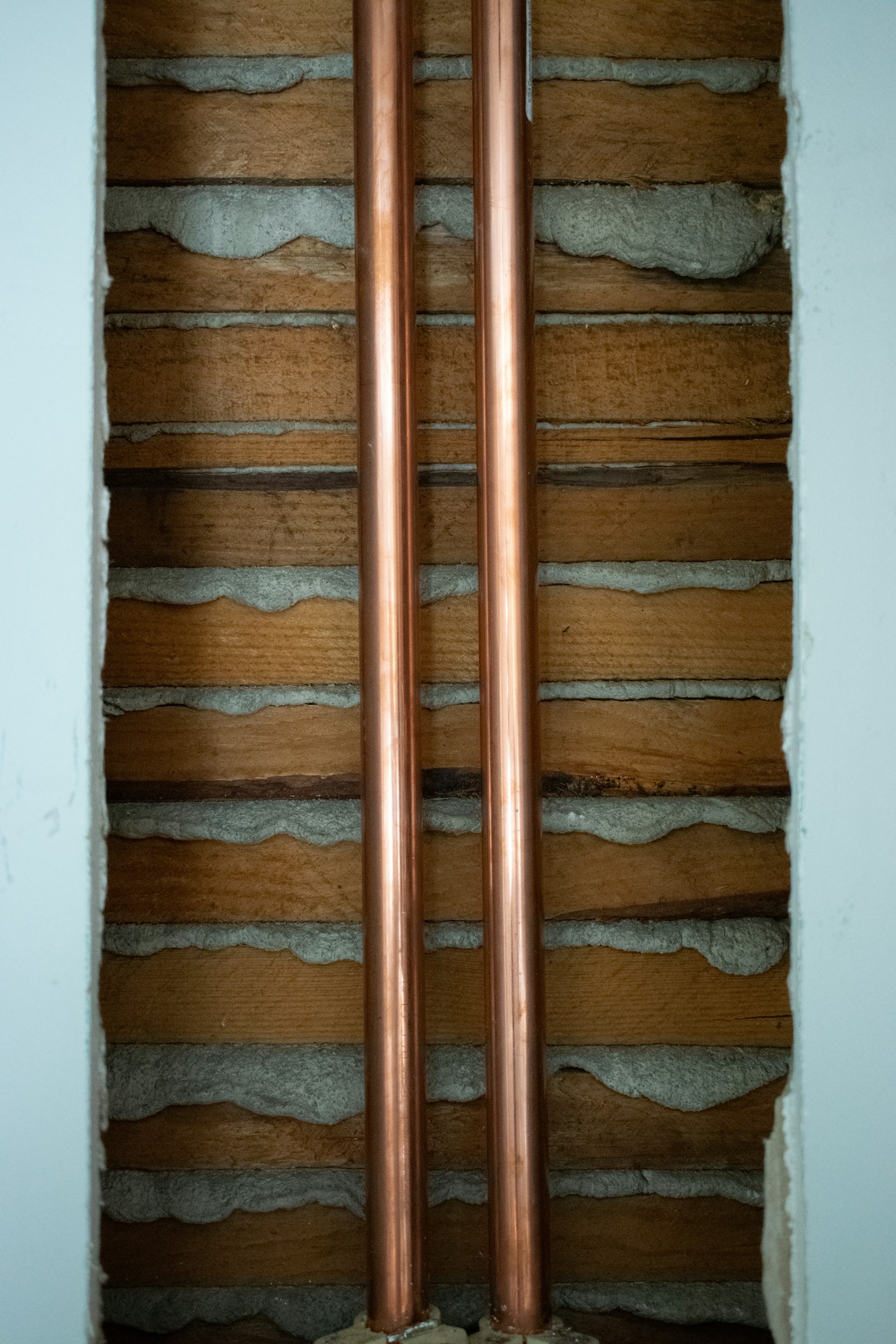 Exposed copper pipework in an unfinished wall